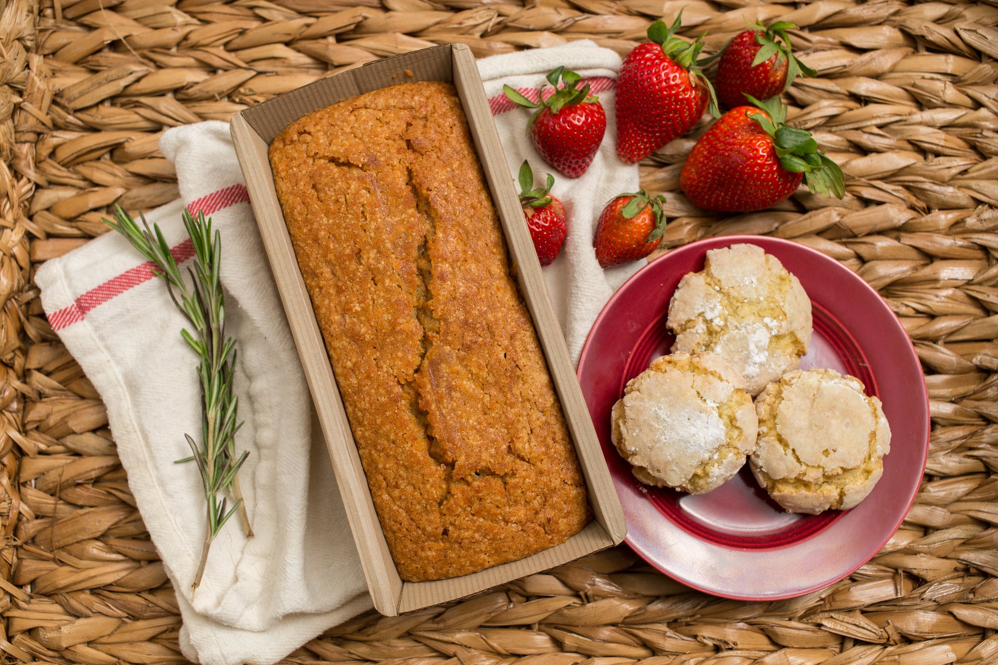 Cardamom Coconut cookies on a red plate, spiced sweet potato cake, and strawberries